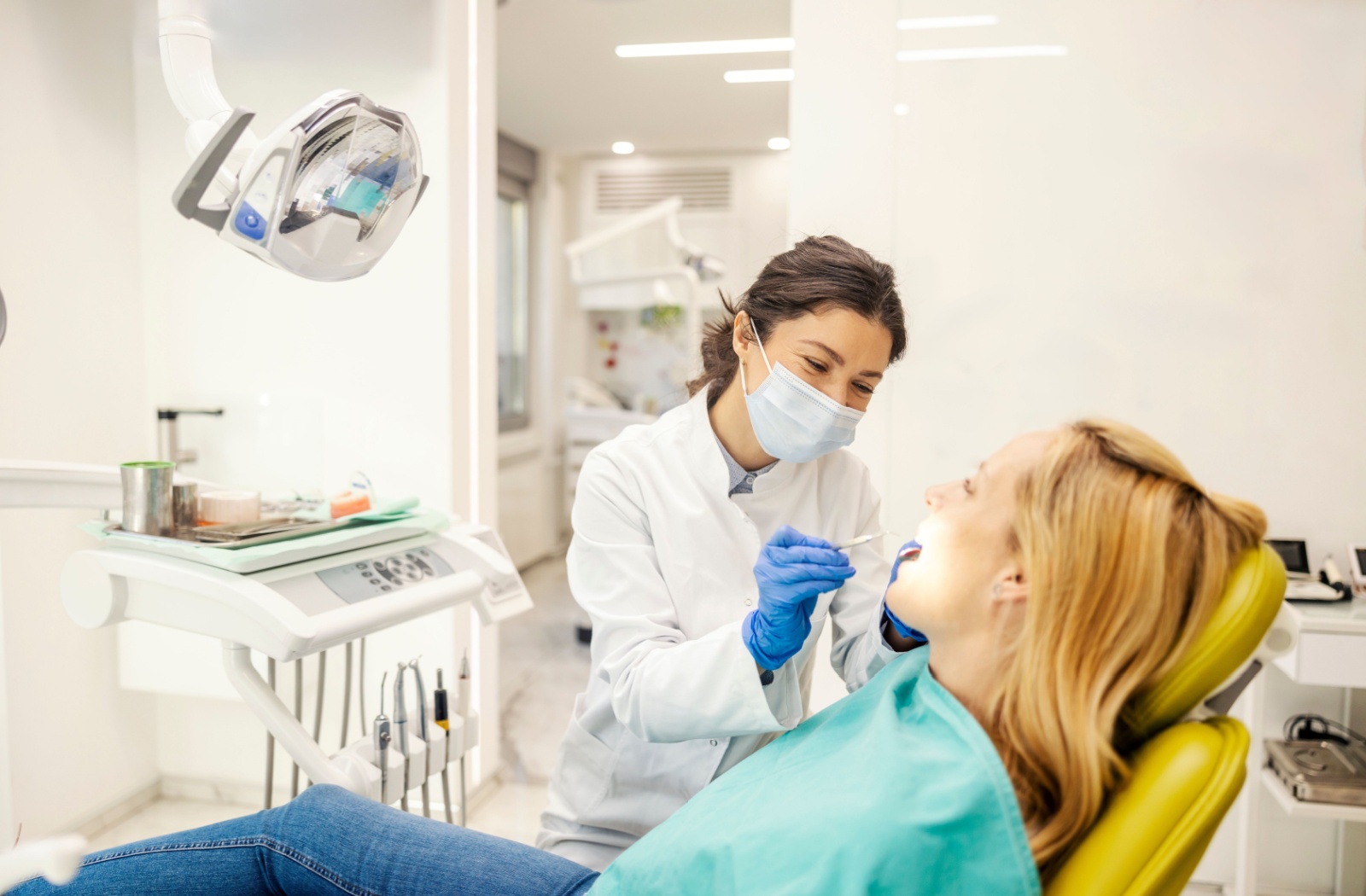 Dentist examining a patient’s teeth and gums during a dental checkup.