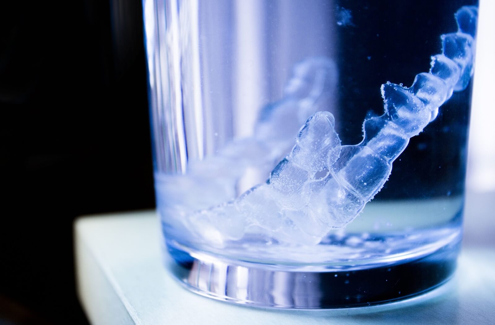 An image of clear aligners sitting in a cleaning solution.